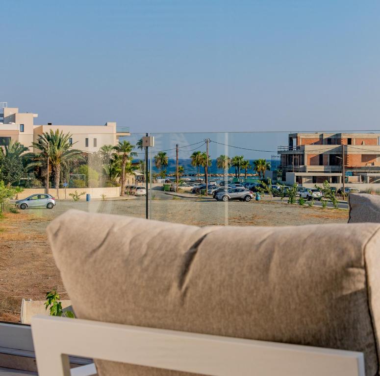 a couch sitting in front of a view of a city at TelMar Sea View - 2 min walk to the Beach in Oroklini