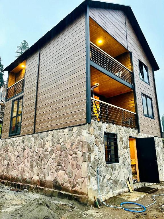 a house is being constructed with a stone wall at Bakhmaro Mountains in Chʼkhakoura