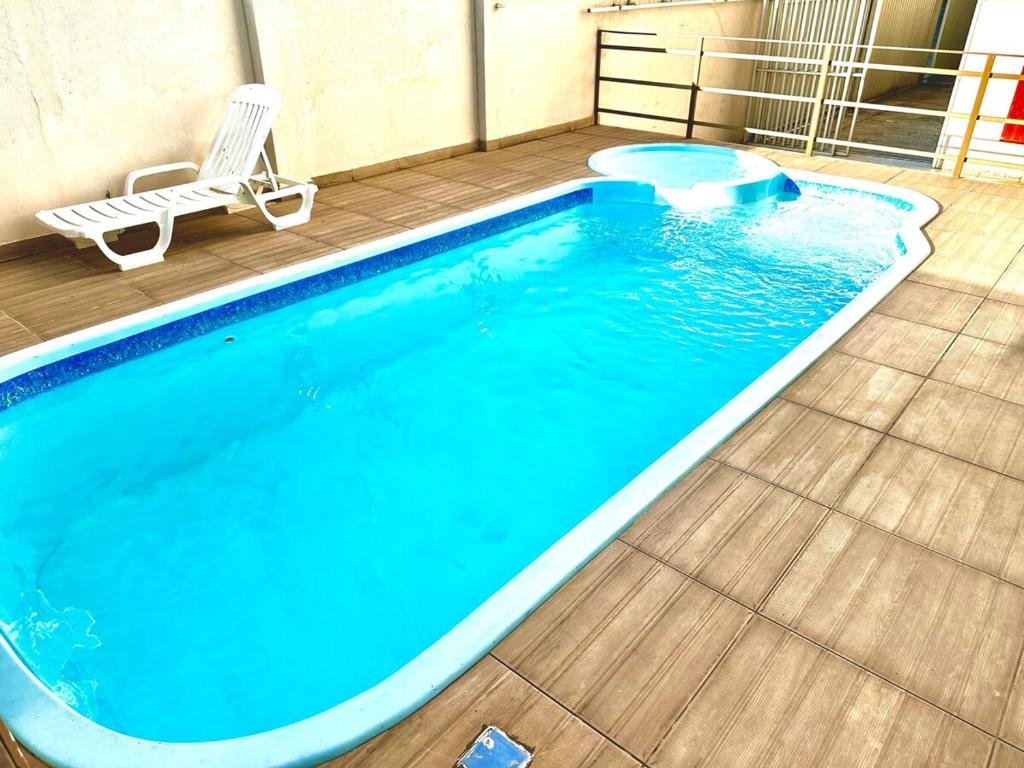 ヴィラ・ヴェーリャにあるM901 Vista Mar Piscina Ar Cond Garagemの椅子とベンチのある大きな青いプール