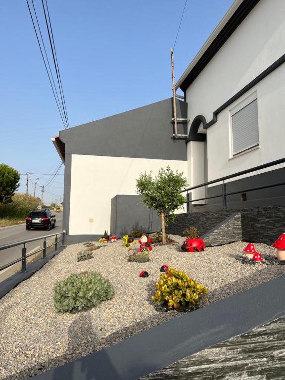 un giardino fiorito sul lato di un edificio di Refúgio Dourado a Lourinhã