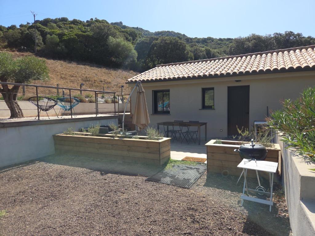 a small house with a patio and a grill at Belle villa à la campagne dans un coin cosy in Sartène
