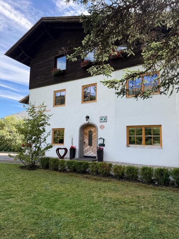 a white house with a black roof at Landhaus Bergfreude in Berwang