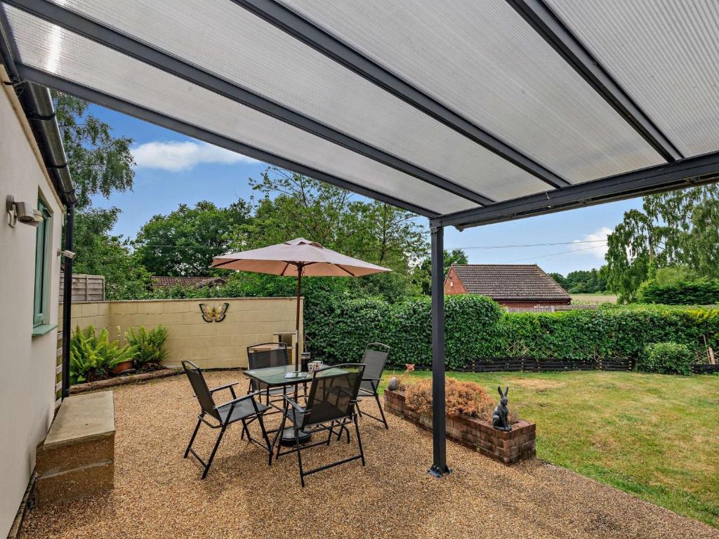 a patio with a table and chairs and an umbrella at 1 Bed in Brundall 46293 in Brundall