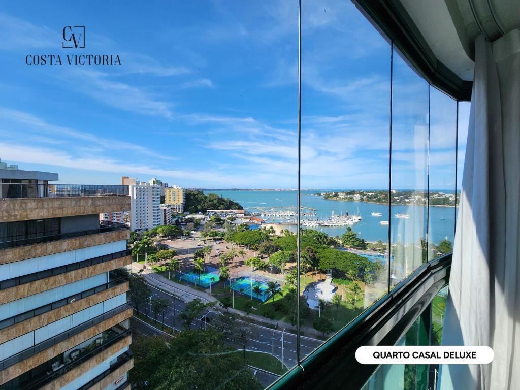 a view of the ocean from a building at Costa Victoria Residence in Vitória