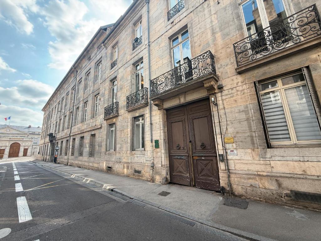 un edificio con una grande porta in legno su una strada di Le Granvelle a Besançon