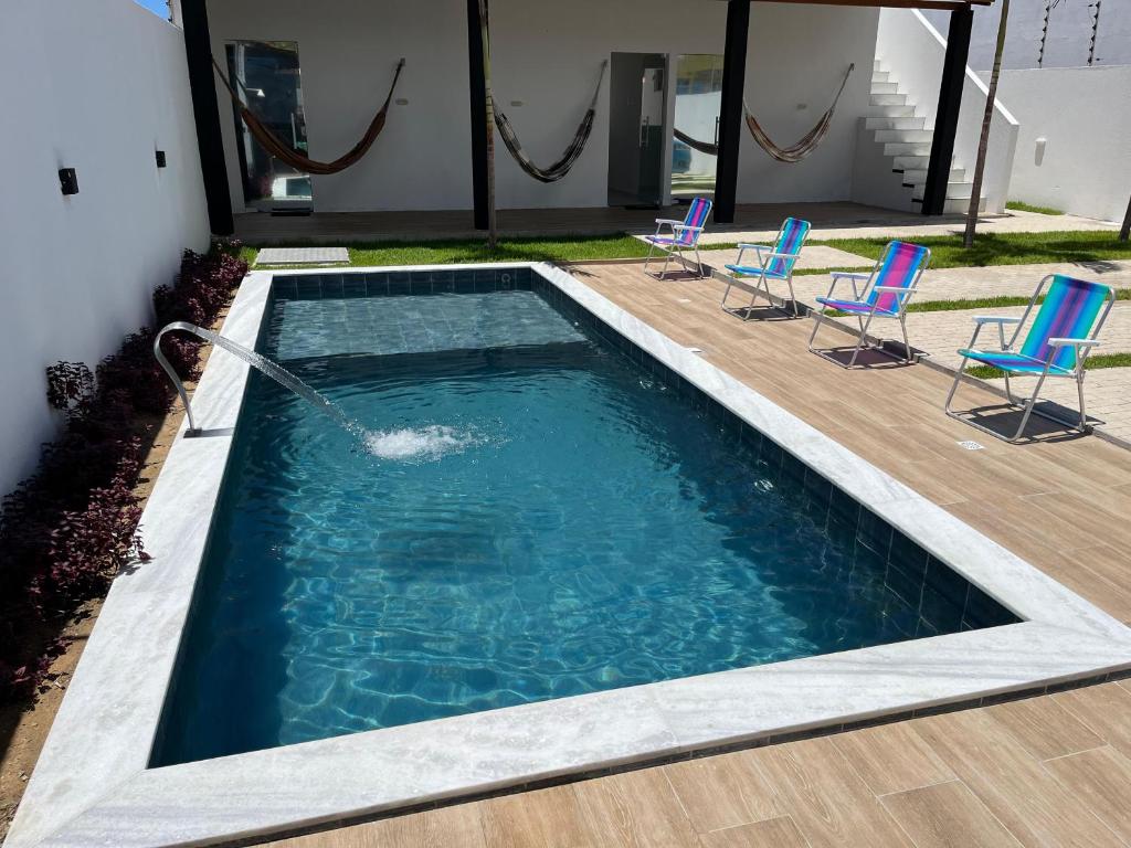 una piscina con sedie e un tubo per l'acqua di Sua casa de praia a Conde