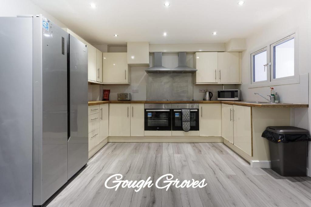 eine Küche mit weißen Schränken und einem Kühlschrank in der Unterkunft Central Derby Ensuite Rooms for Contractor Stays in Derby