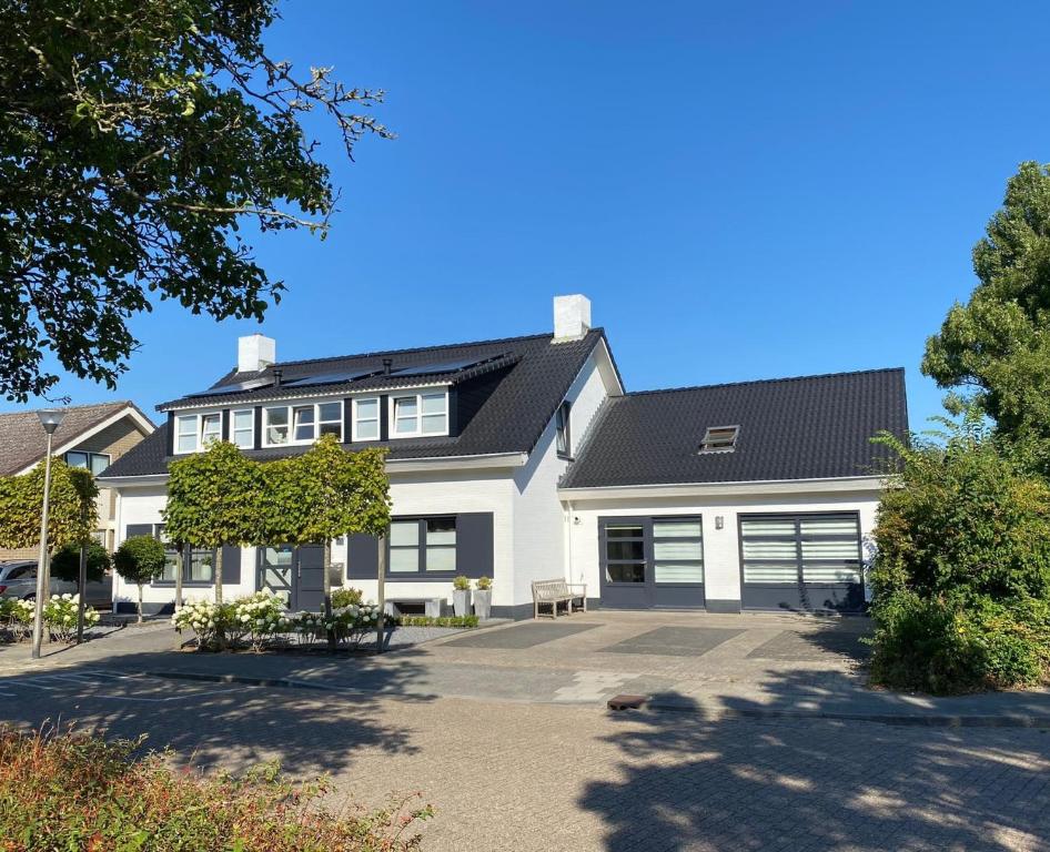 a large white house with a black roof at Duinoord Domburg in Domburg