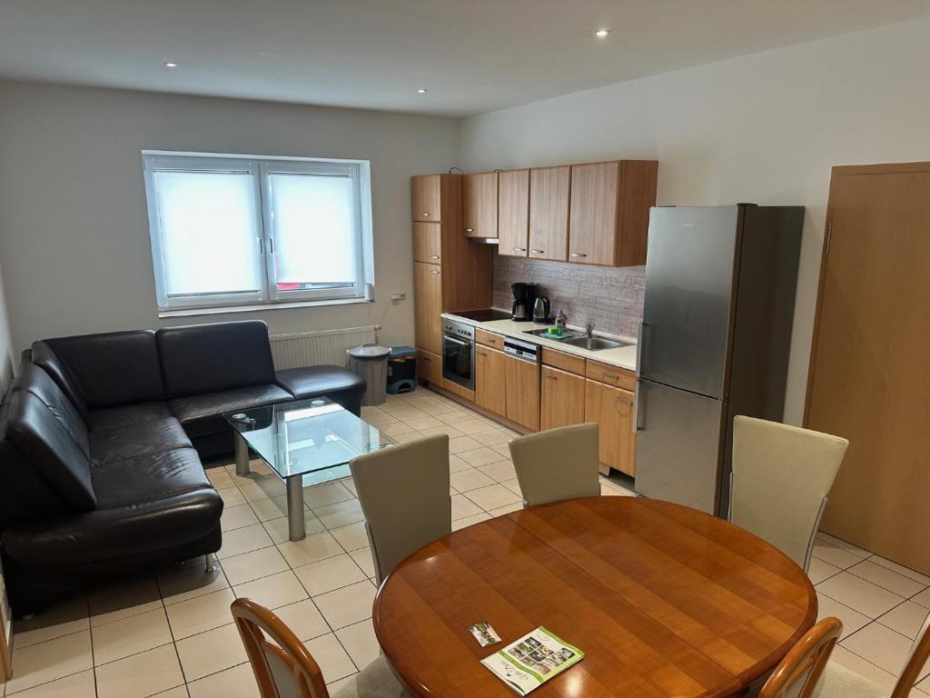 eine Küche und ein Wohnzimmer mit einem Tisch und einer Couch in der Unterkunft 3 Schlafzimmer, Wohnzimmer, Küche, Bad, Terrasse, Parkplatz in Wörrstadt