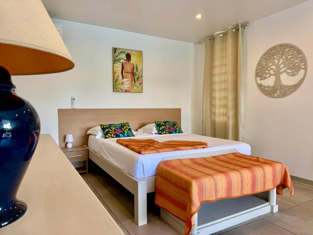 a bedroom with a bed and a table with a lamp at Villa TULIA in Sainte-Luce