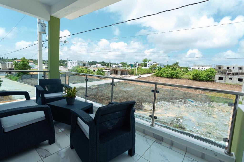 Un balcón con sillas y vista a una ciudad. en Ventura Living, en Nagua