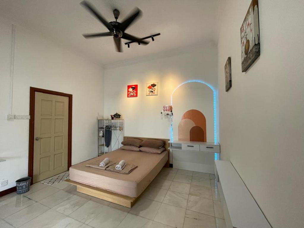 a bedroom with a bed and a ceiling fan at Merdeka 19A in Taiping