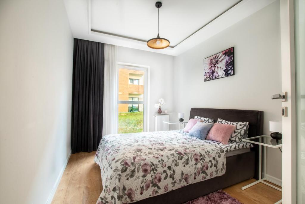 a bedroom with a bed and a window at Apartament GB przy PCK 3A z bezpłatnym parkingiem by Gingerbread Apartments in Toruń