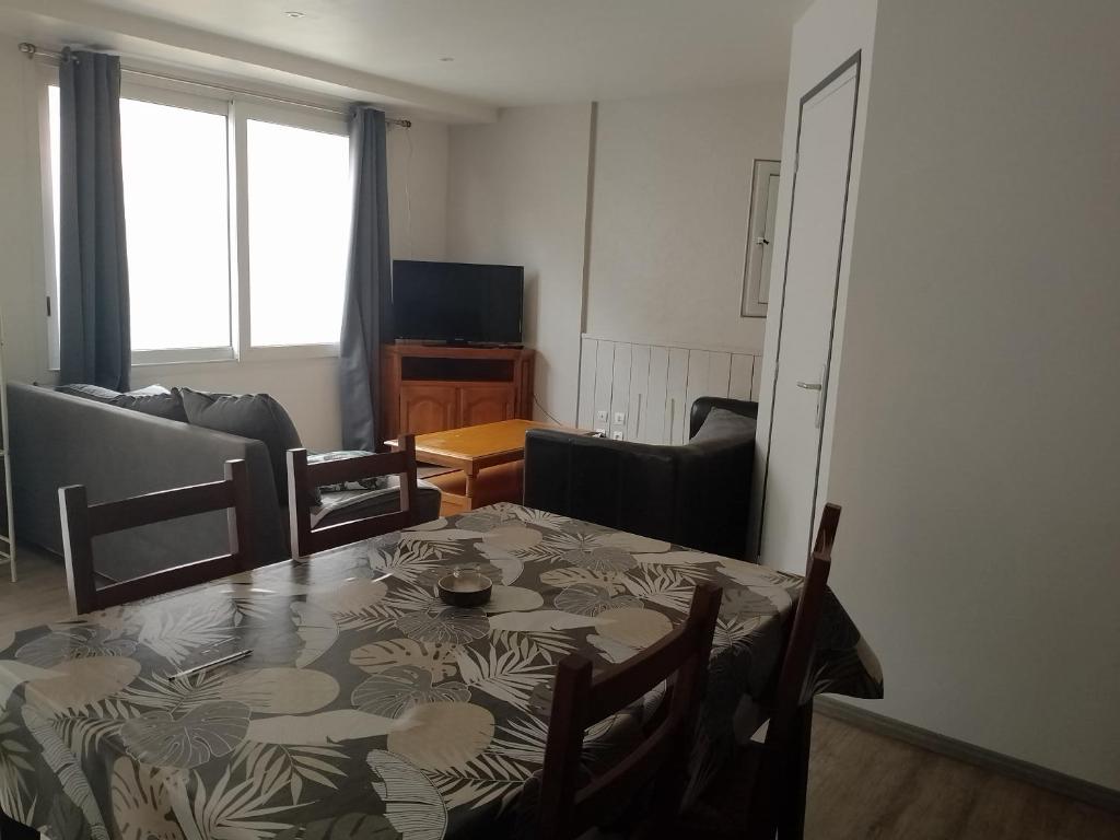 ein Wohnzimmer mit einem Tisch und einem Sofa in der Unterkunft Appartement rez de chaussé 60m2 in Montreuil-sur-Ille