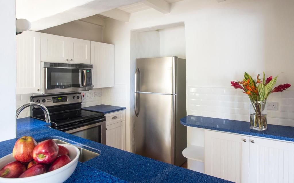 Kitchen with white cabinets, blue granite countertop, stainless steel appliances, and fresh fruit.