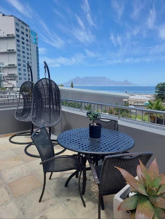 a patio with a table and chairs on a balcony at Infinity LG3 in Cape Town