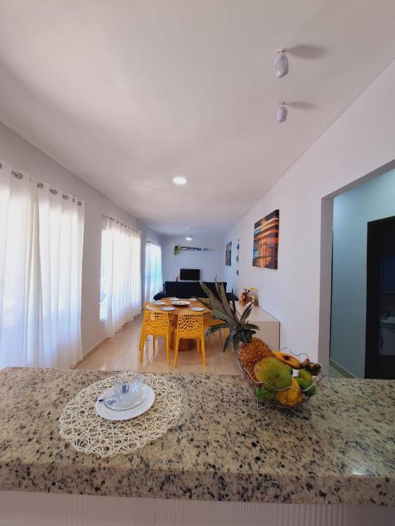 a living room with a table with a pineapple on a counter at La casa Azul- Búzios in Búzios