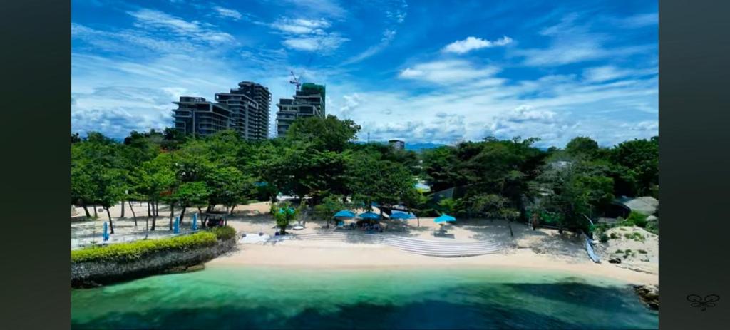 a beach with chairs and umbrellas in a park at Rent Homecation at Tambuli Seaside Living in Maribago