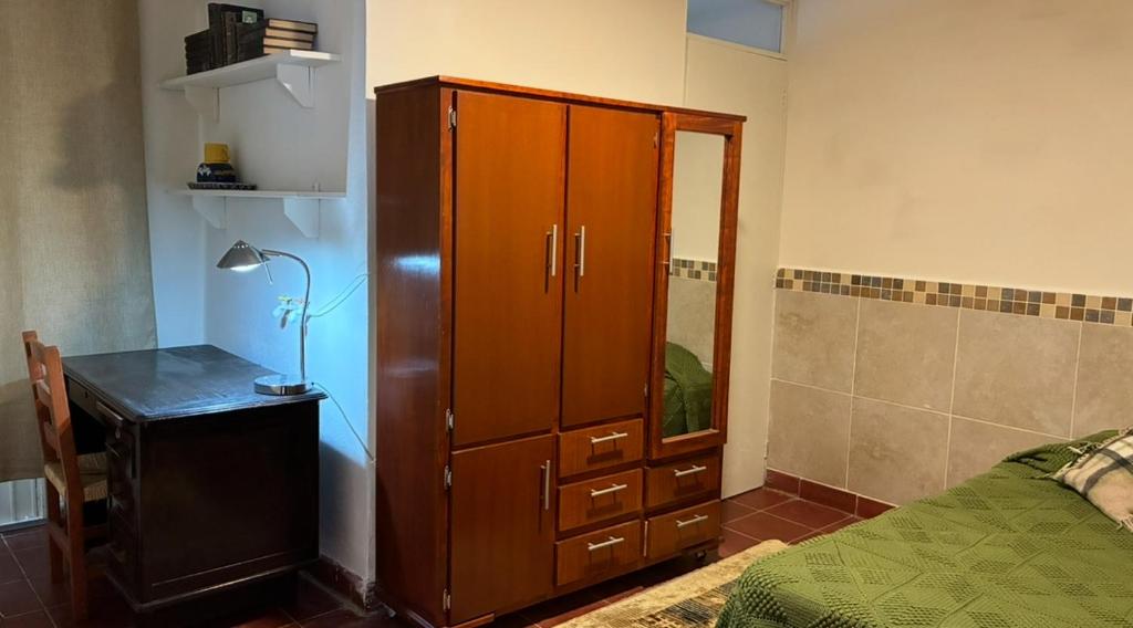 een slaapkamer met een houten kast en een bed bij Habitación in Morelia