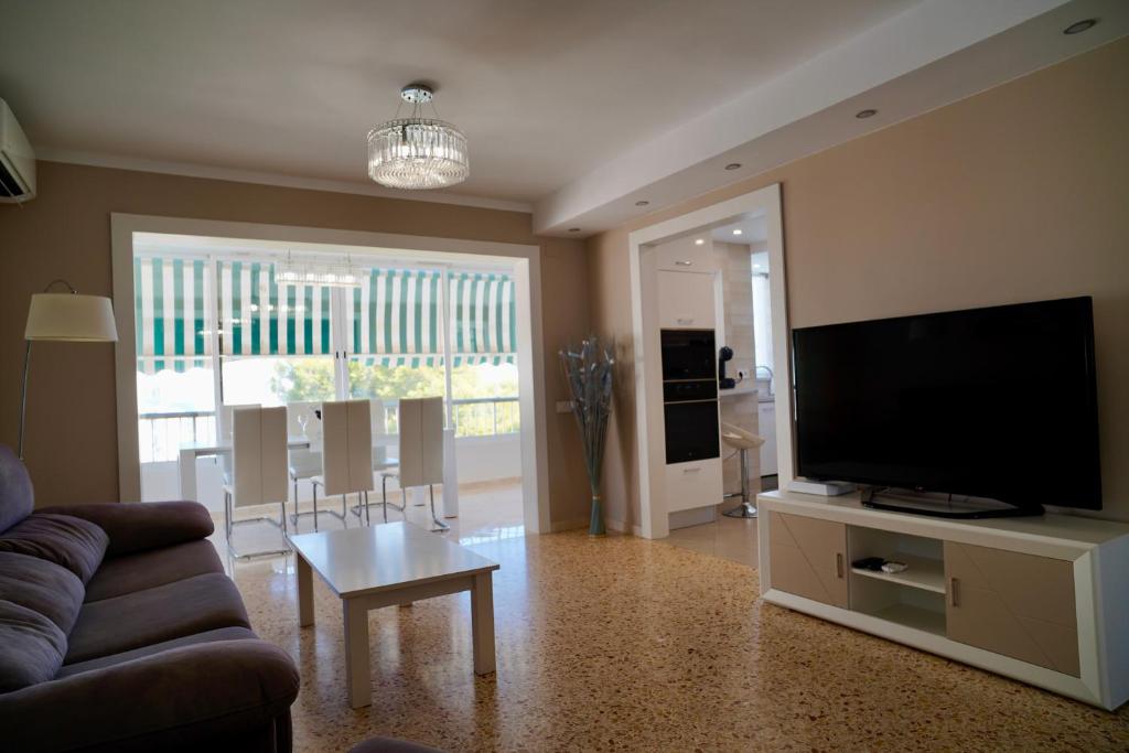 Una sala de estar con un sofá y un televisor de pantalla plana. en Apartamento Parque 2 Playa de Gandía, en Playa de Gandía