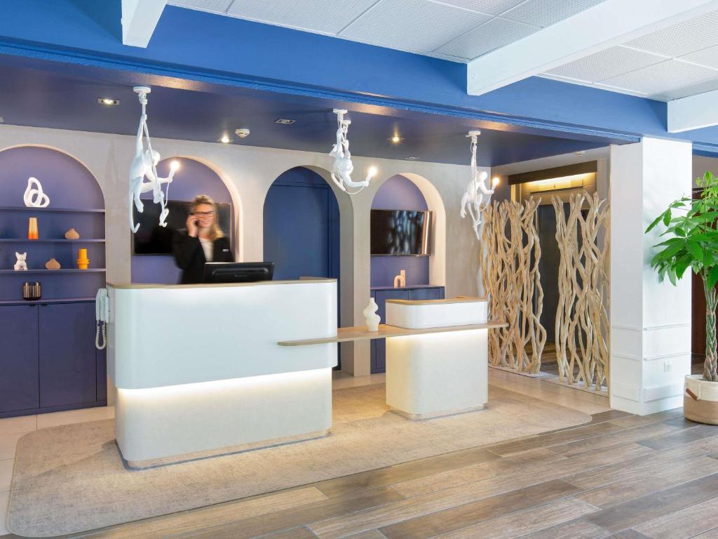 a store with a counter in a room with purple walls at Novotel Aix-en-Provence Pont de L'Arc in Aix-en-Provence