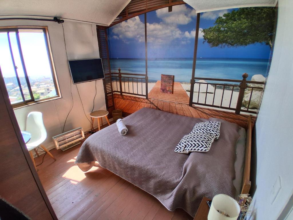 a bedroom with a bed and a view of the ocean at habitación con vista al mar Altavista Hostal in Valparaíso