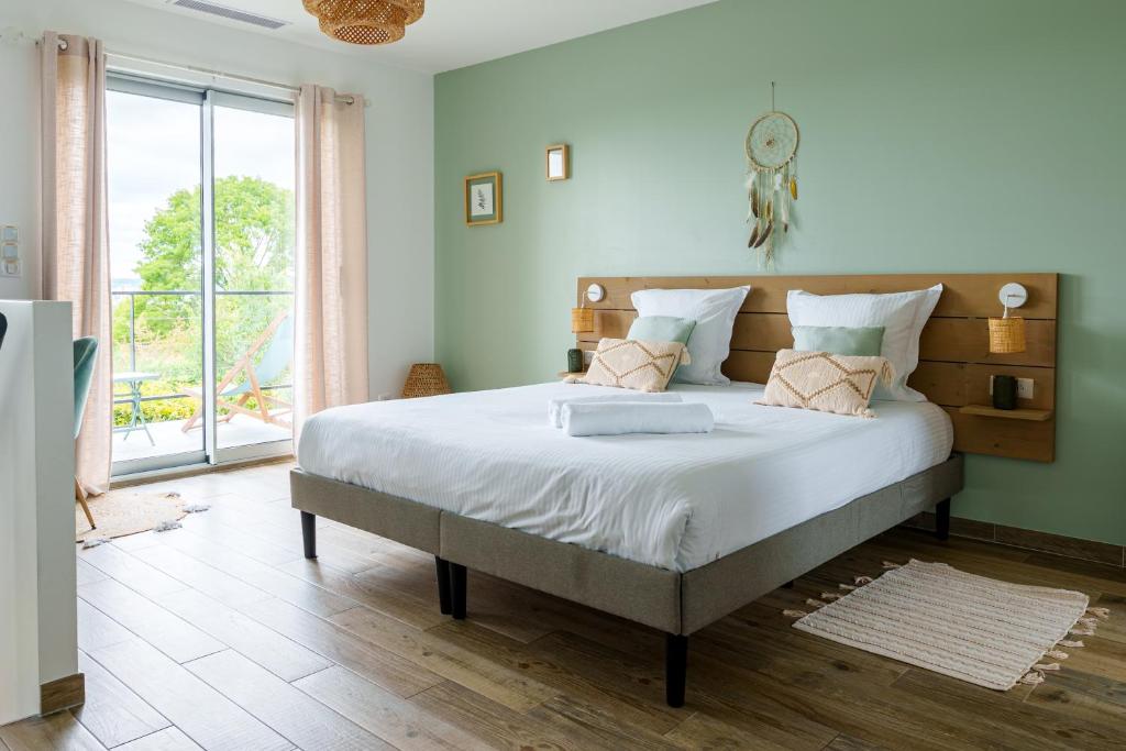 a bedroom with a large bed with a large window at La Villa Perchée, Appartements Élégants, sauna Privé, sport, terrasses et Vue Panoramique, Parking protégé, proche PARIS in Saint-Prix