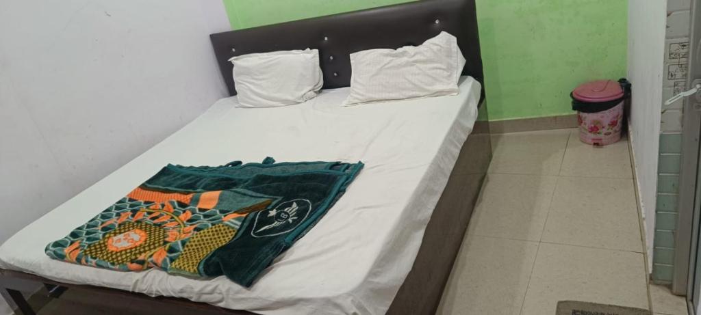 a bed in a room with white sheets at Hotel V L in Lucknow