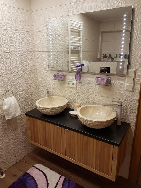Baño con 2 lavabos y espejo en DD Apartments Zell am See, en Zell am See