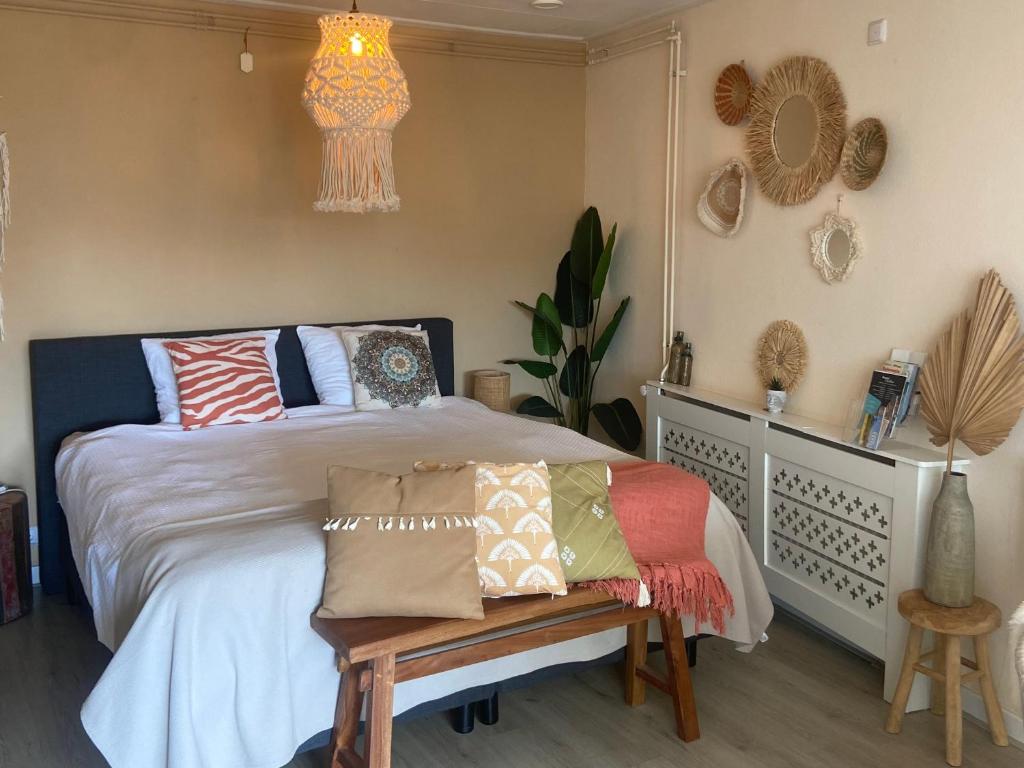 デ・コーフにあるBed en Koffie Casa Mañana de Koogのベッドルーム1室(ベッド1台、ベンチ、枕付)