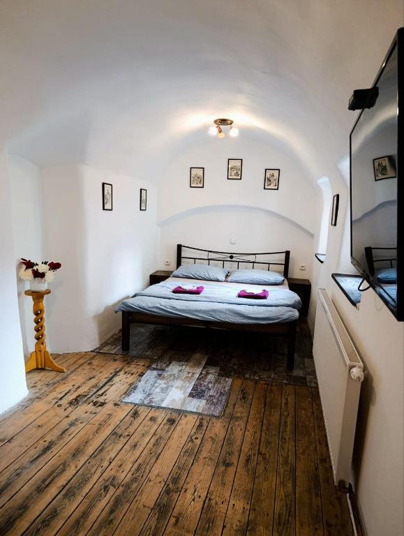 a bedroom with a bed and a wooden floor at Apartment B B B in Český Krumlov
