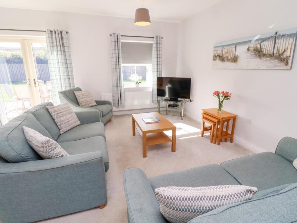 a living room with two couches and a tv at The Haven in Alnwick