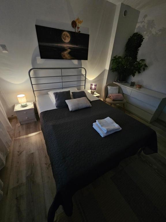 una camera da letto con un letto nero con due asciugamani di Domowe Zacisze a Szamotuły