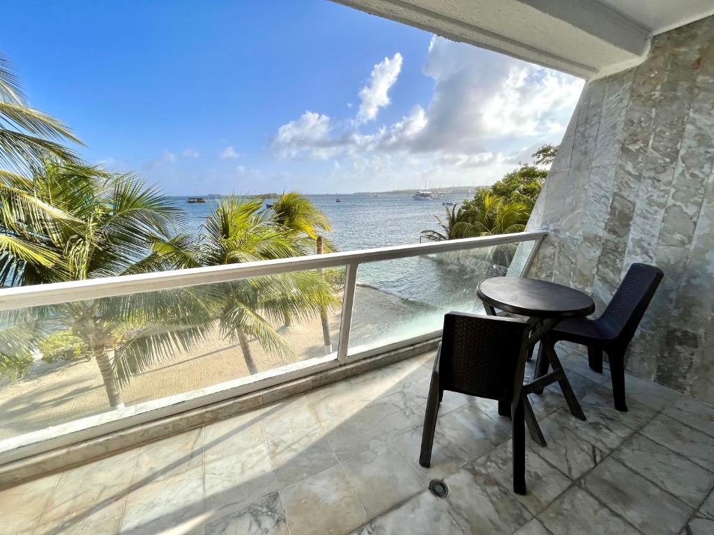 a balcony with a table and chairs and the ocean at Aptos Sunrise Beach in San Andrés
