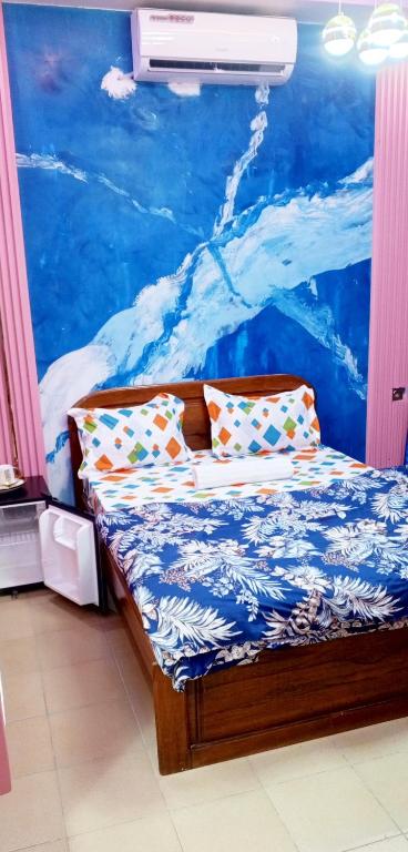 a bed with pillows in a room with a mural at RÉSIDENCE NGUARy in Dakar