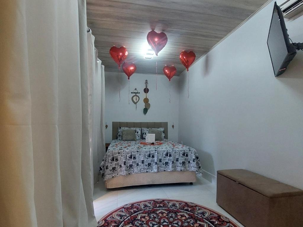 Un dormitorio con una cama con corazones rojos en el techo. en Chalé na lata, en Pirenópolis