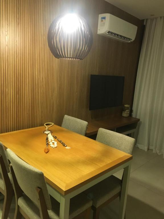 a room with a wooden table with chairs and a light at Aqualand Resort in Salinópolis