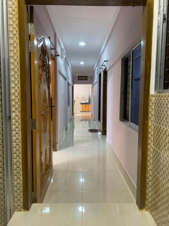a hallway of a building with white tile floors at Dream Palace in Sylhet