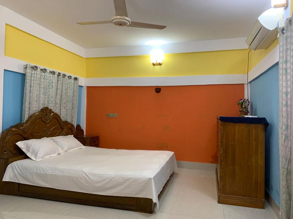 a bedroom with an orange and blue wall at Dream Palace in Sylhet