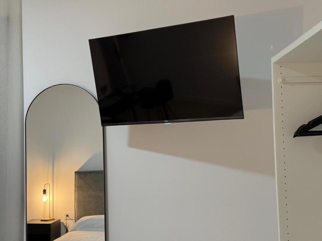 a flat screen tv on a wall in a bedroom at M&A Hostal in Bechí
