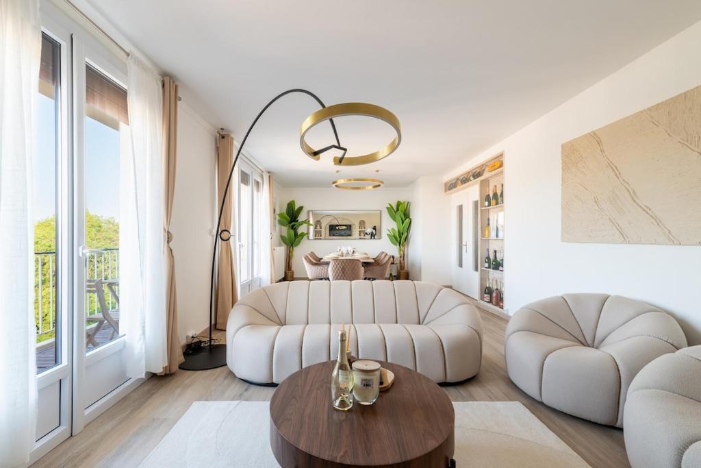 a living room with two white couches and a table at Luxurious 3 Bedrooms Sauna Jacuzzi in Tinqueux