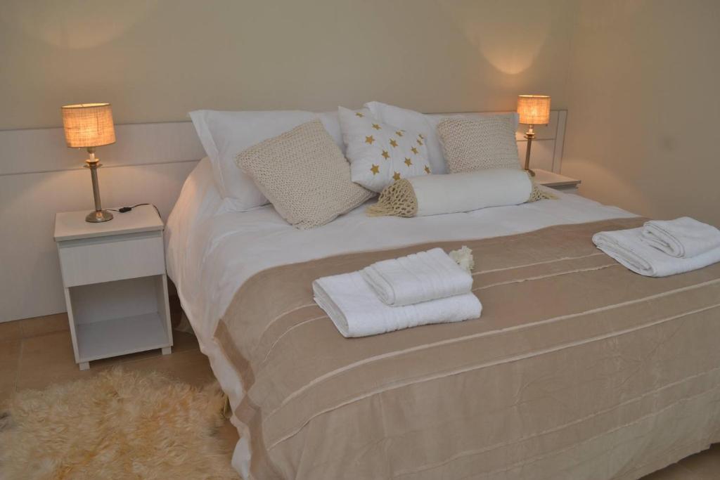 una camera da letto con un grande letto con asciugamani di Apart Boutique Macedonia a San Lorenzo