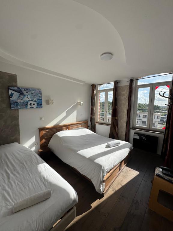 une chambre avec deux lits et une fenêtre dans l'établissement Hôtel de France Tey Resort, à Lens