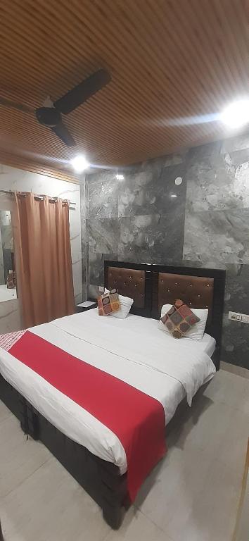 a bedroom with a large bed with a red blanket at Hotel Metro Residency Kalkaji in New Delhi