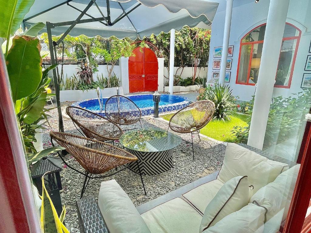 Un patio con mesa y sillas y una piscina. en Holi Dolce Vita Pool Villa, en Nha Trang