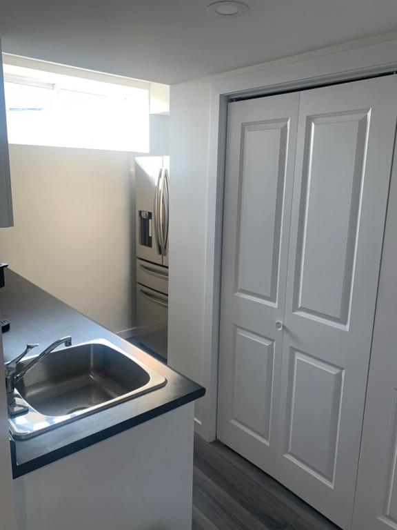a kitchen with a sink and a door at Friendly Extended Stay and Comfort in Winnipeg