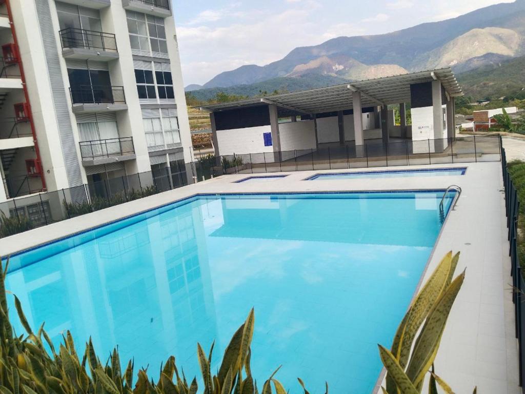 a large blue swimming pool in front of a building at Apartamento en melgar tolima in Melgar