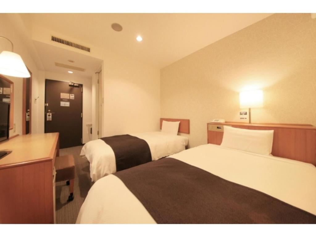 東京にあるSmile Hotel Tokyo Ayase Ekimae - Vacation STAY 14744vのベッド2台とテレビがあるホテルの部屋