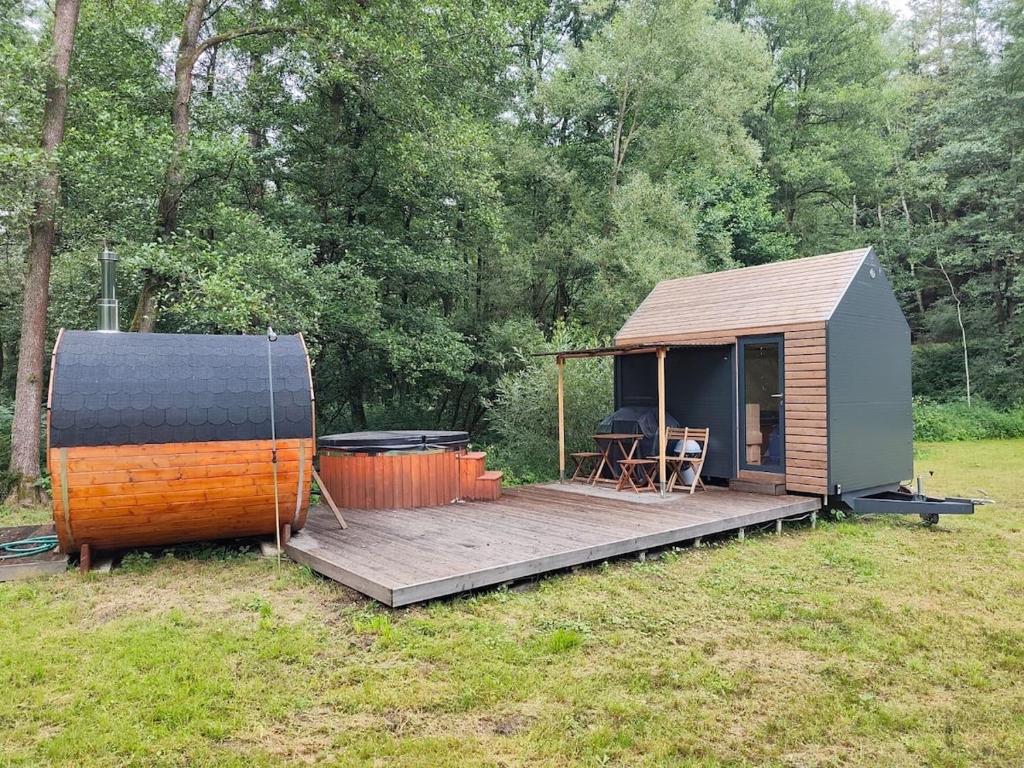 una piccola cabina con terrazza e griglia di Glamping Všímarský Stream a Malšín