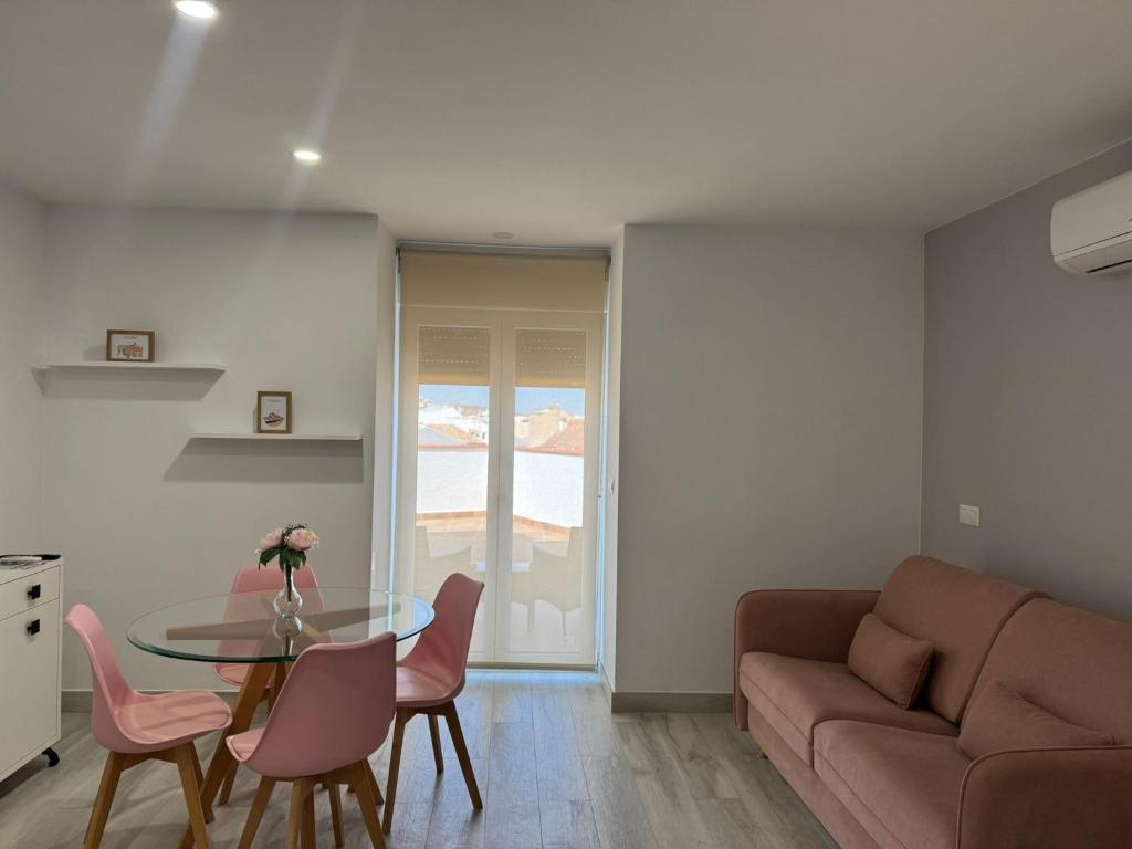 una sala de estar con una mesa y un sofá en Hotel Apartamentos Antequera, en Antequera